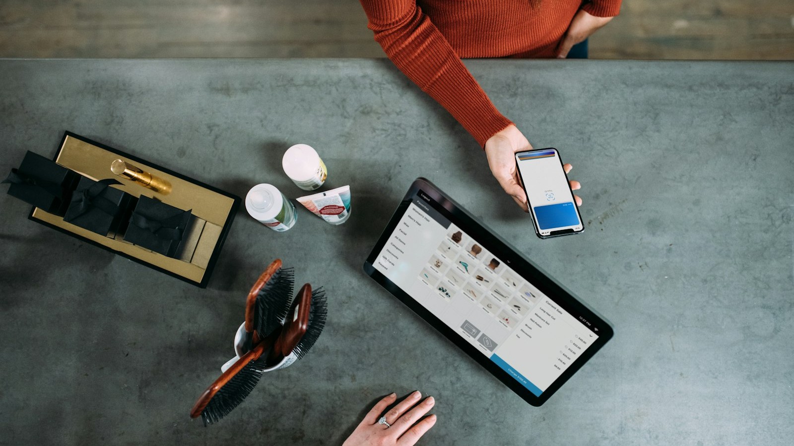 Hand tapping a bank card on a POS terminal, bright retail payment scene